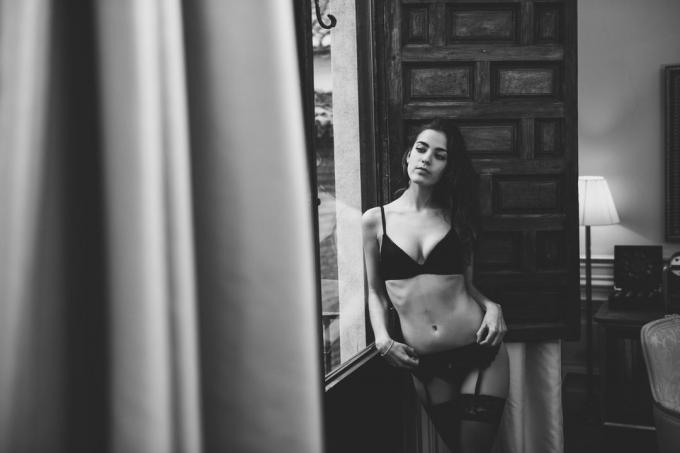 एक खिड़की के पास अधोवस्त्र मुद्राओं का में सेक्सी जवान औरत