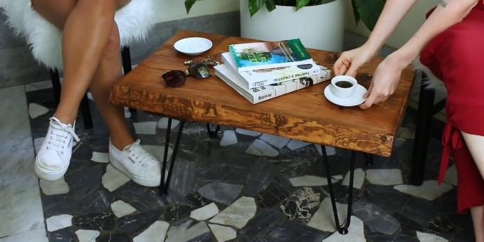 एक कॉफी को अपने हाथों के साथ बोर्ड के बने टेबल बनाने के लिए